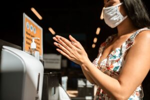 woman with mask washing hands